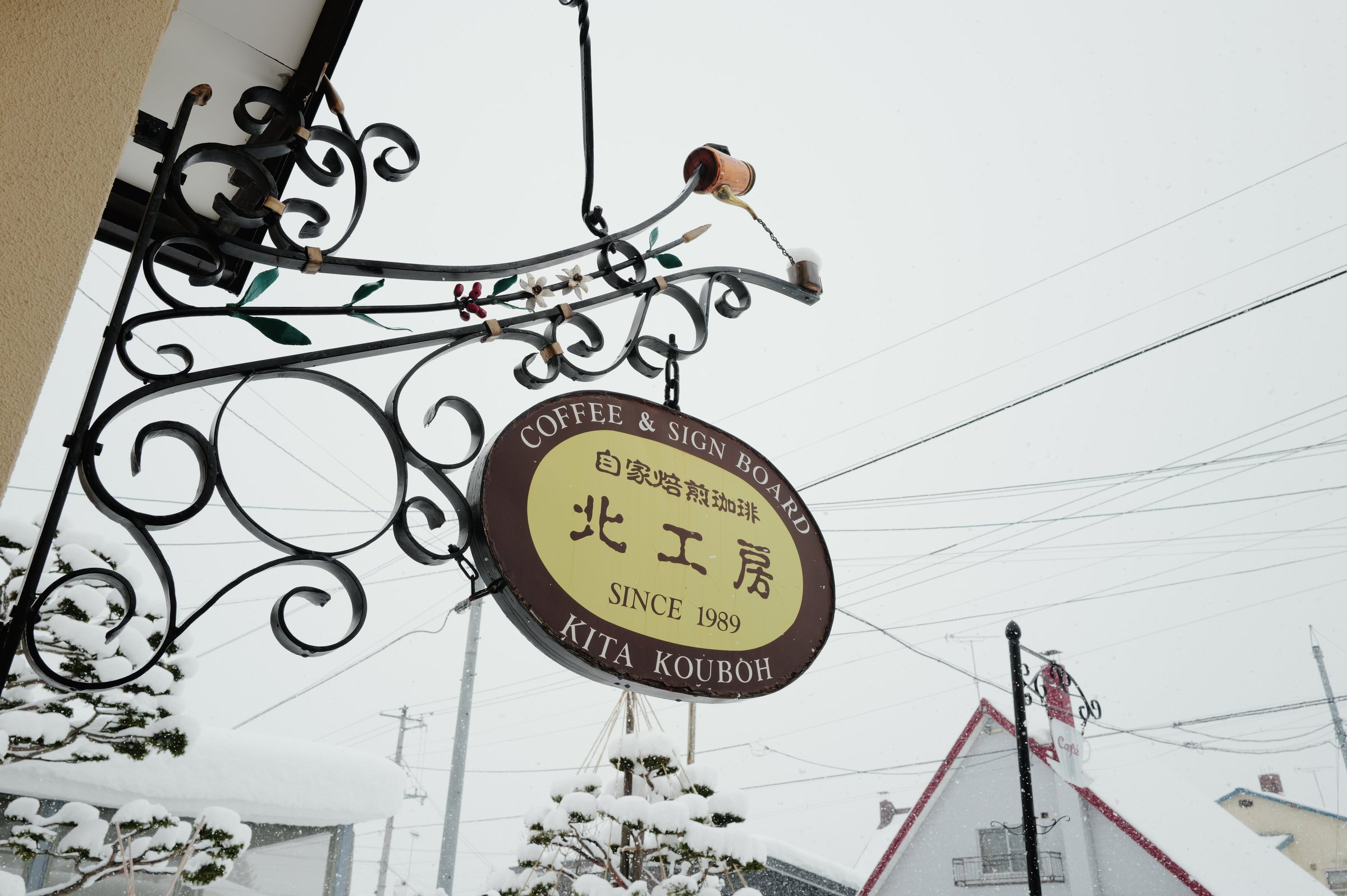 鉄の飾りから吊るされた「北工房」の楕円の看板