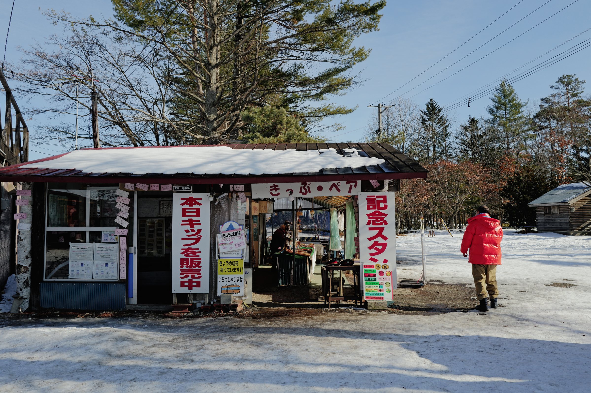 木立の中の売店と、赤い上着の人