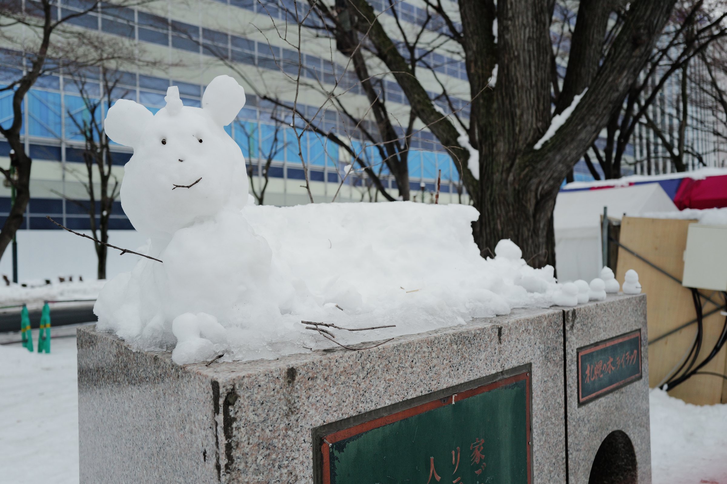 石碑の上に置かれた、雪でつくった小さな動物