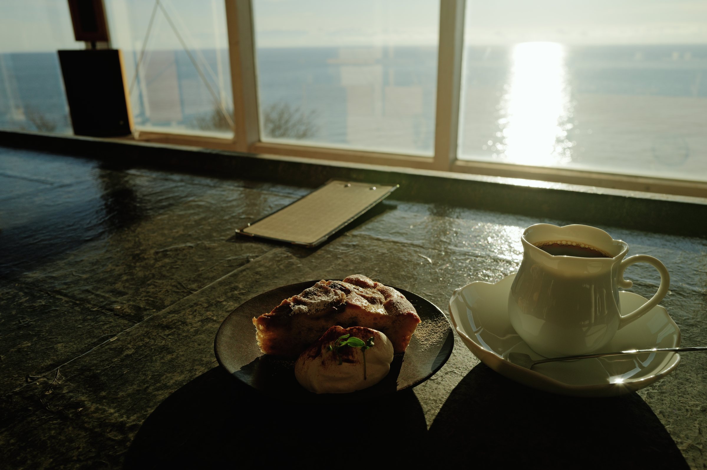 海を背にしたテーブルの、ケーキとコーヒー