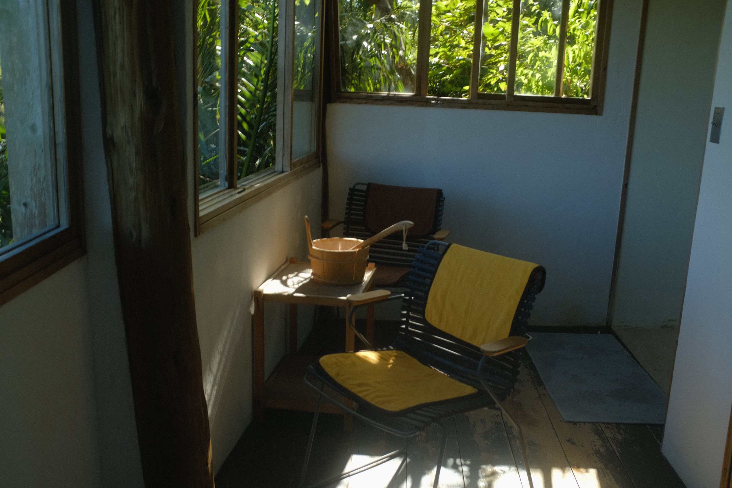 窓から光の入る小さな部屋と、黄色い椅子