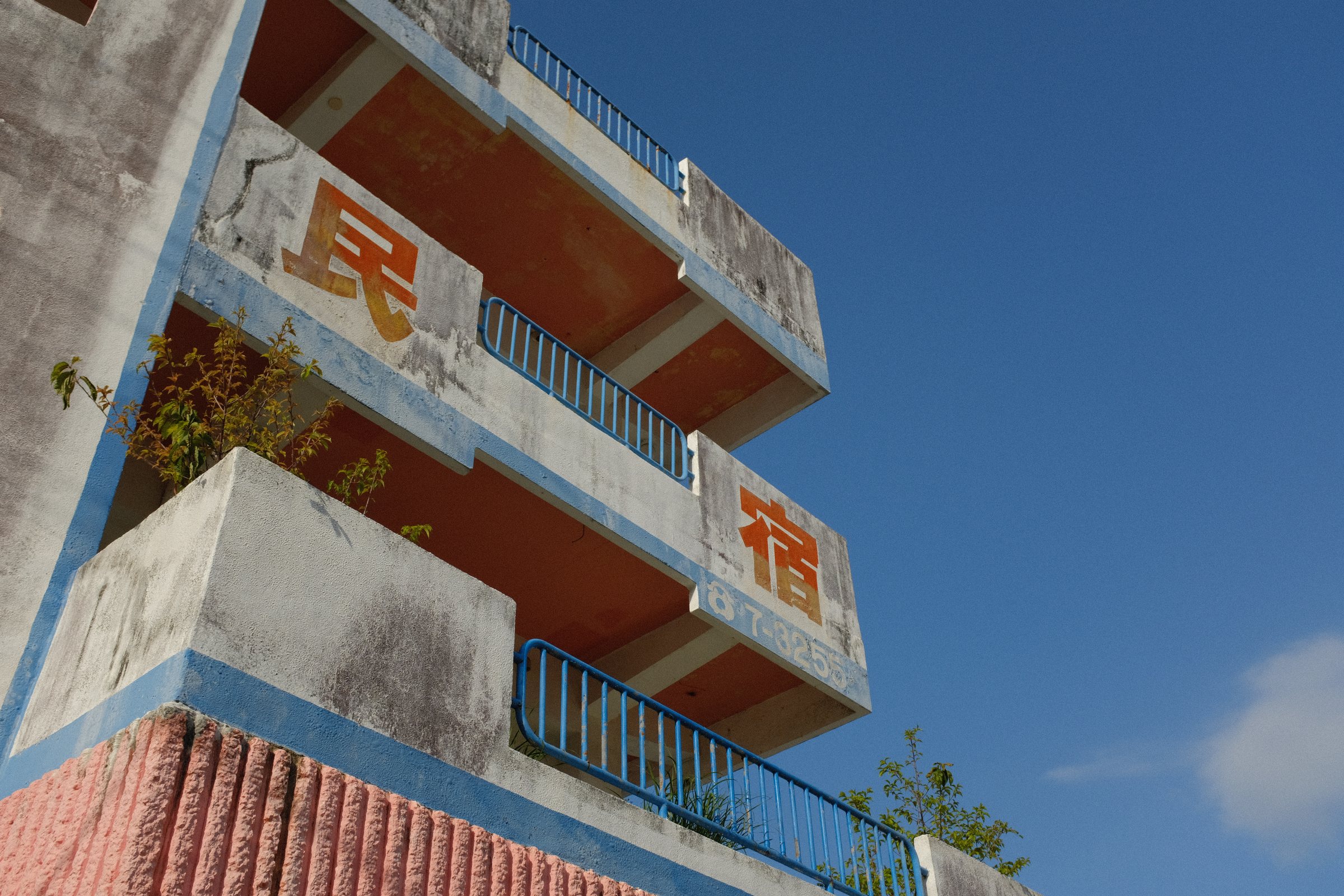 見上げた建物の壁に大きく書かれた「民」と「宿」の文字