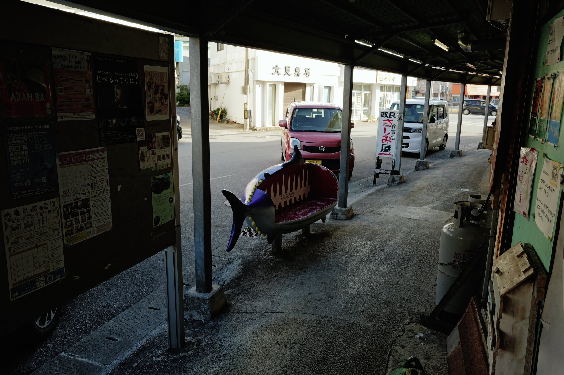 市場の通路に置かれた、魚の形をしたベンチ