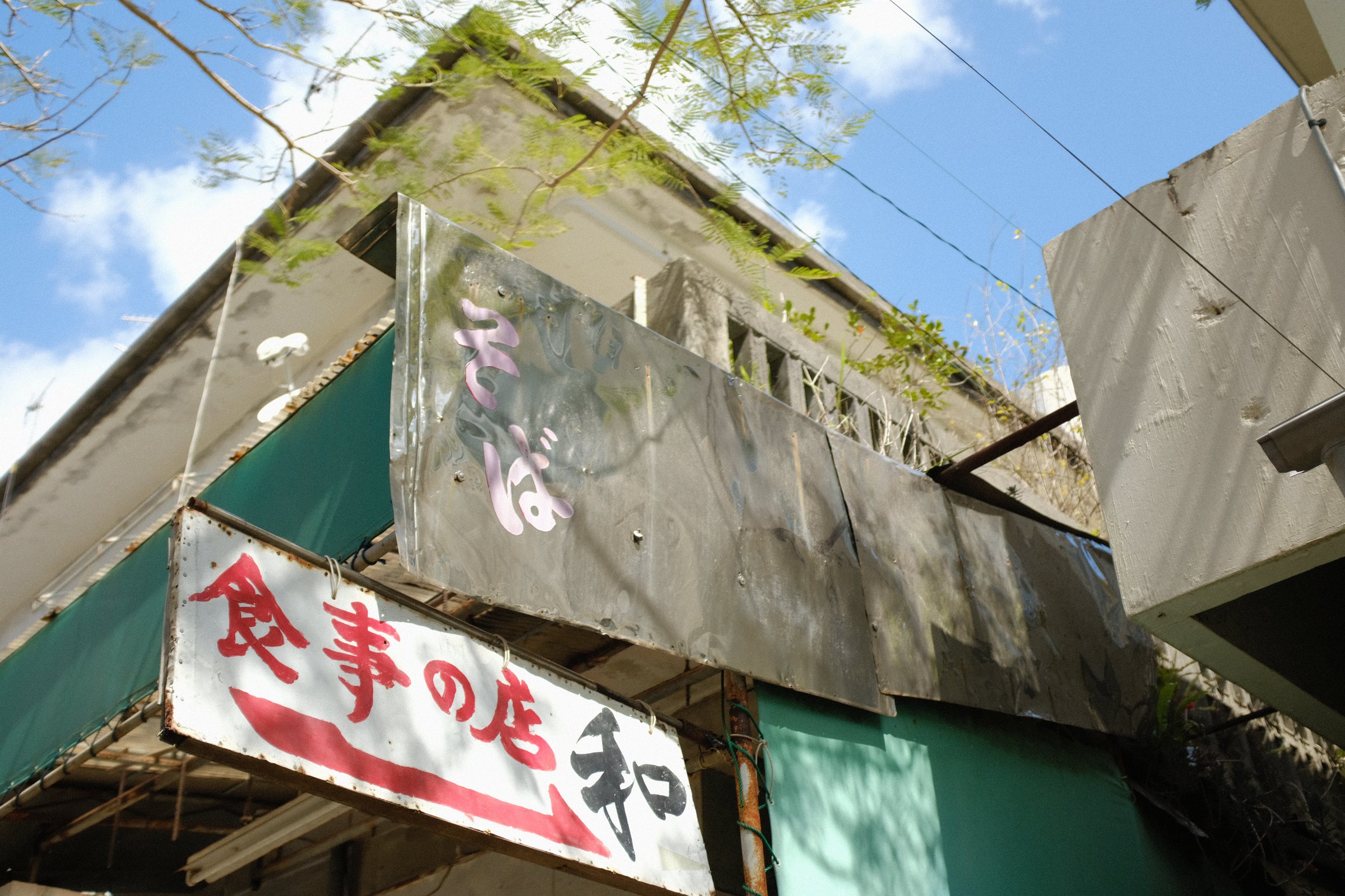 見上げた古い建物に残る「食事の店」の看板