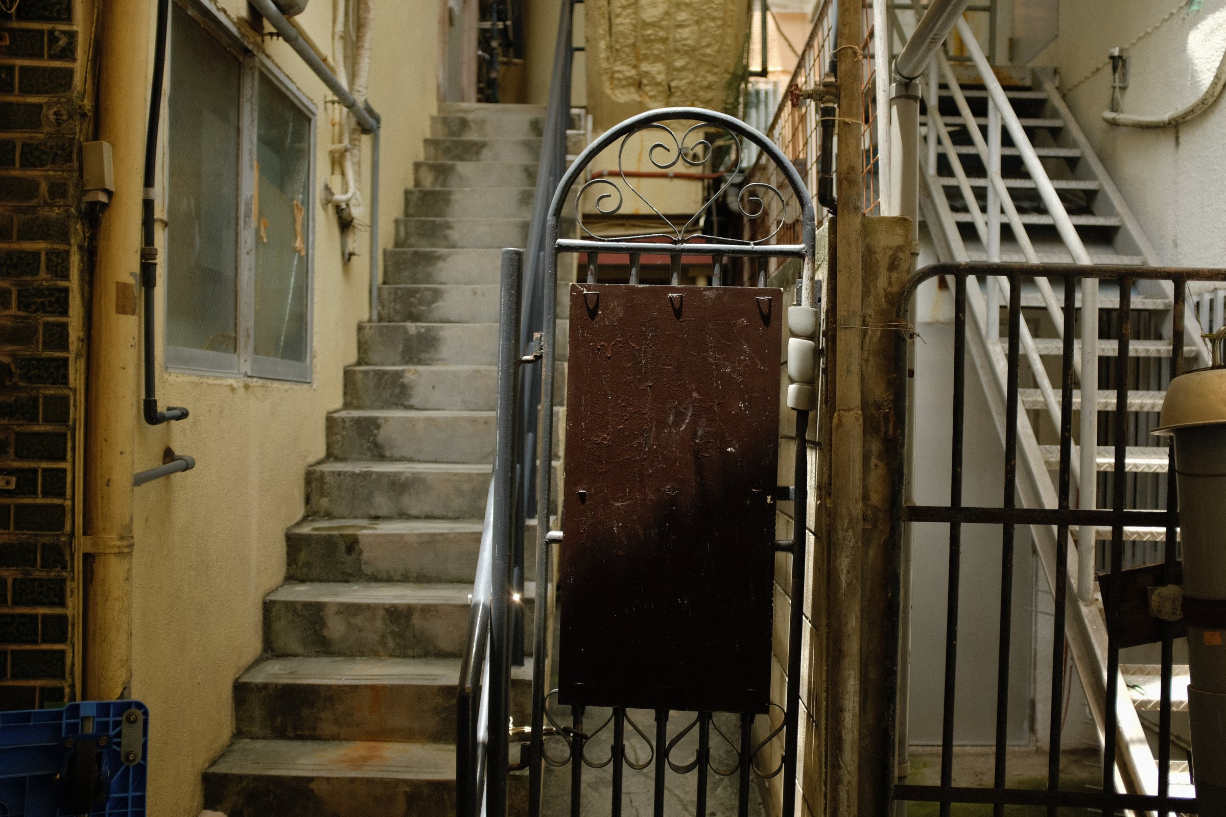 建物のあいだの細い路地に続く、白い階段と門