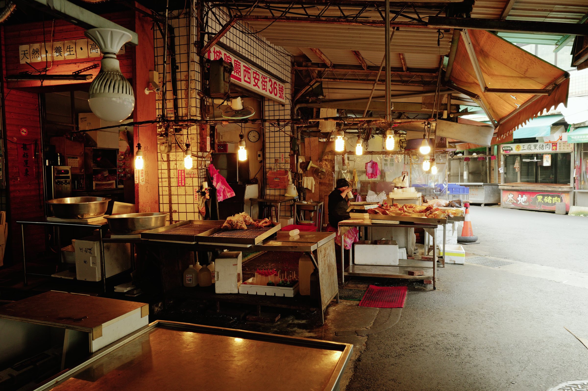 吊るした電球に照らされた市場の奥の店
