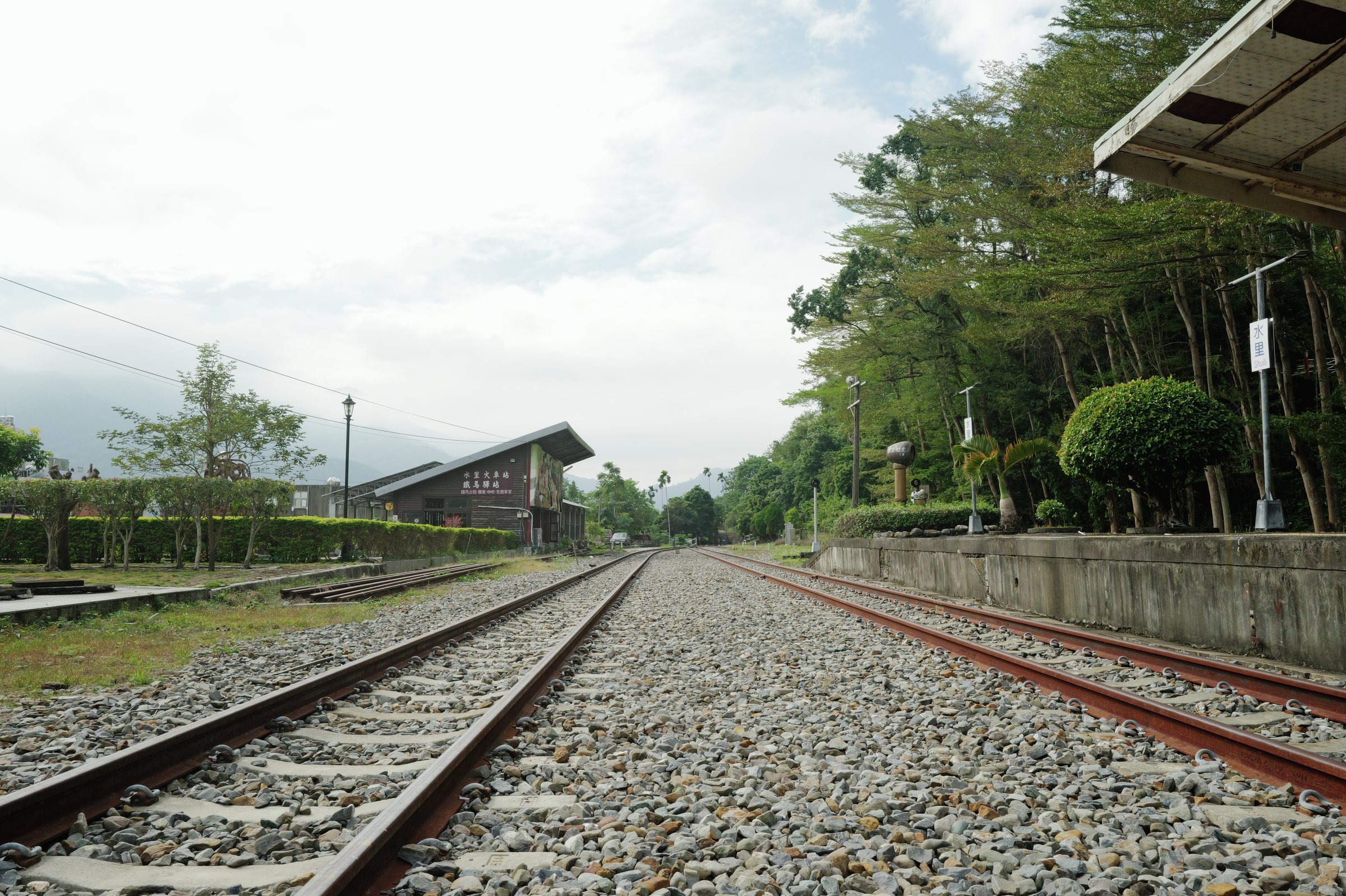 駅から延びる線路と、その先の木々と山