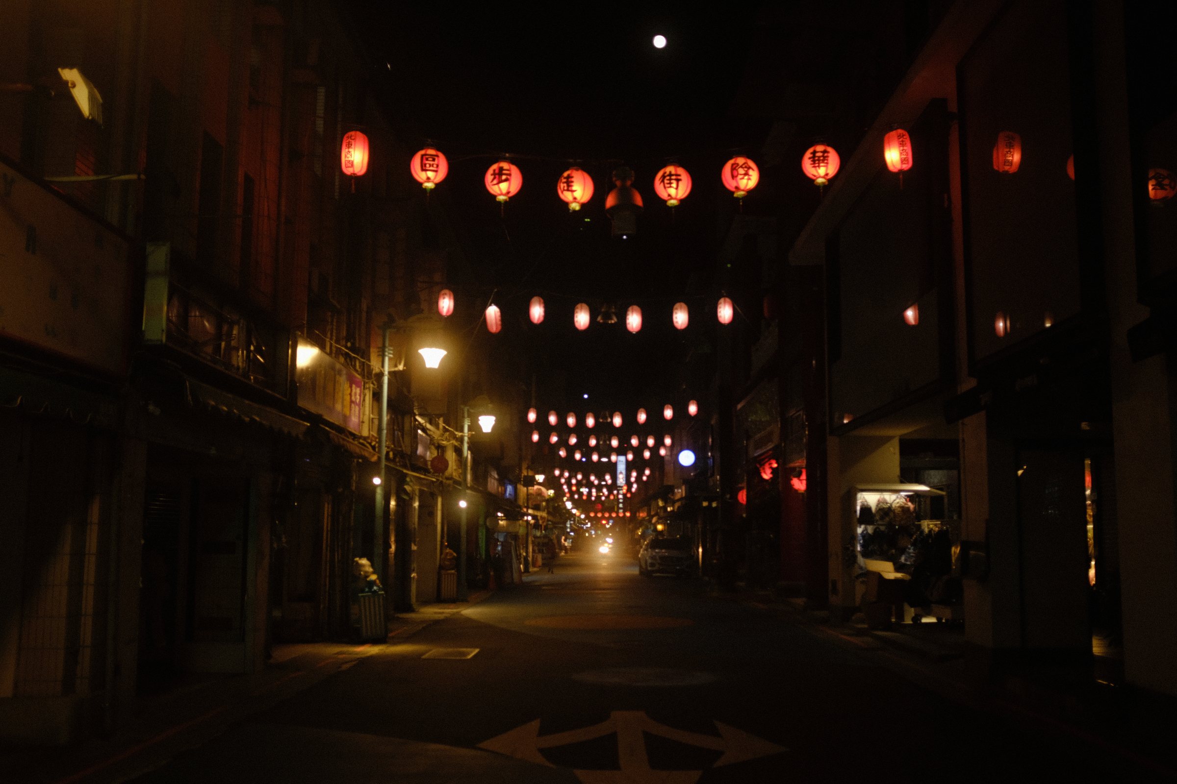 赤い提灯が奥まで続く、人のいない夜の路地