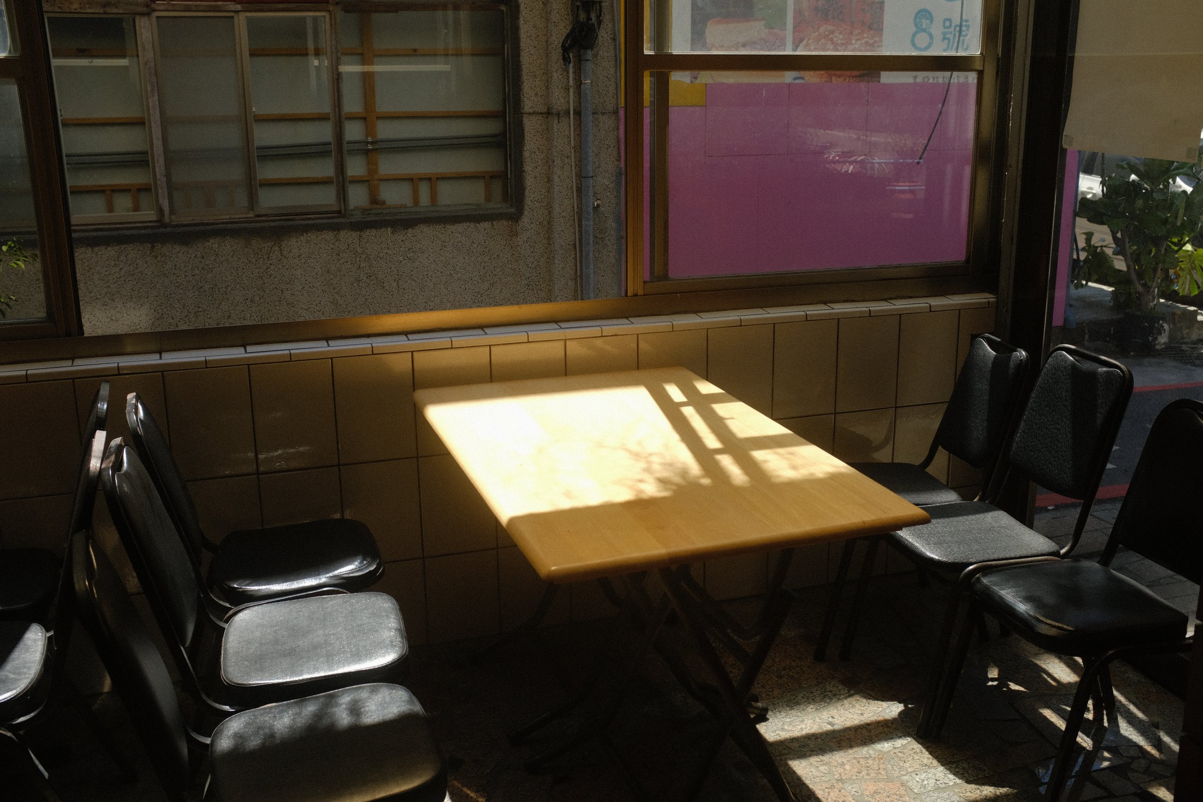 冰店の窓際のテーブルに、窓枠の形をした光が落ちている