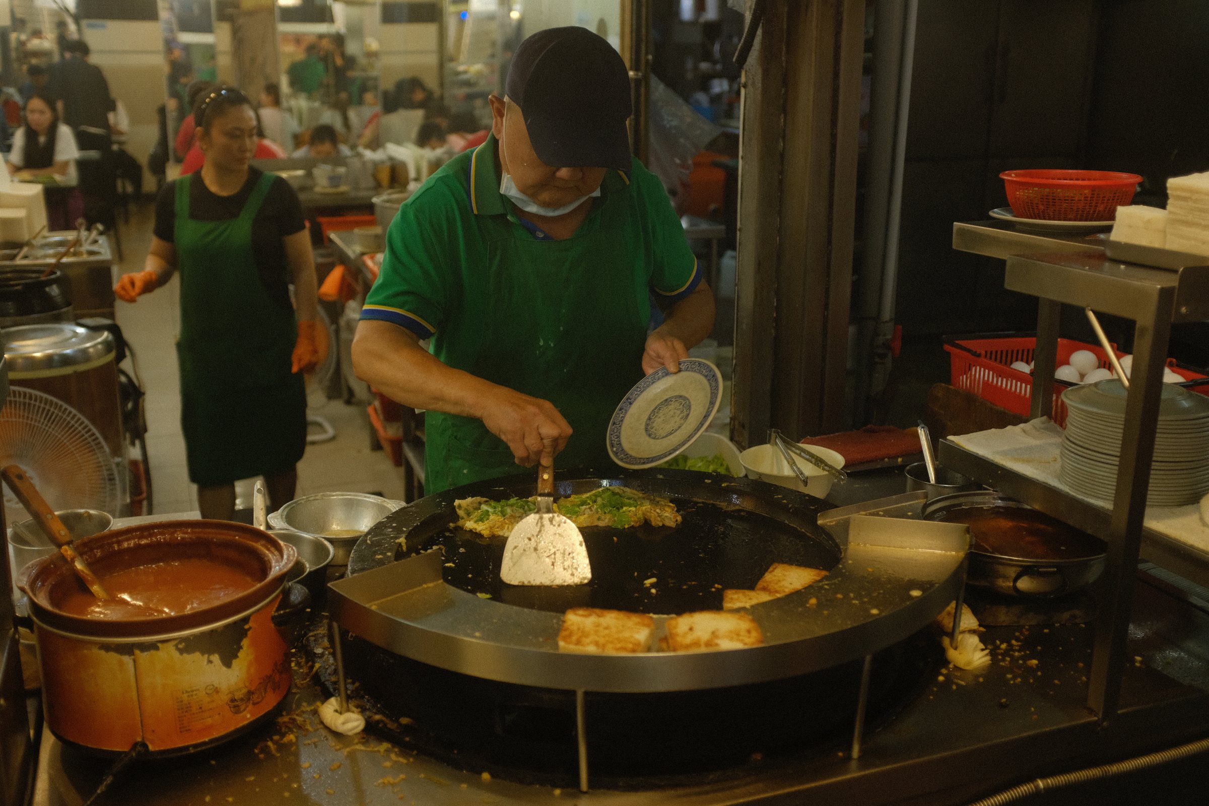 夜市の丸い鉄板の前で手を動かす店の人
