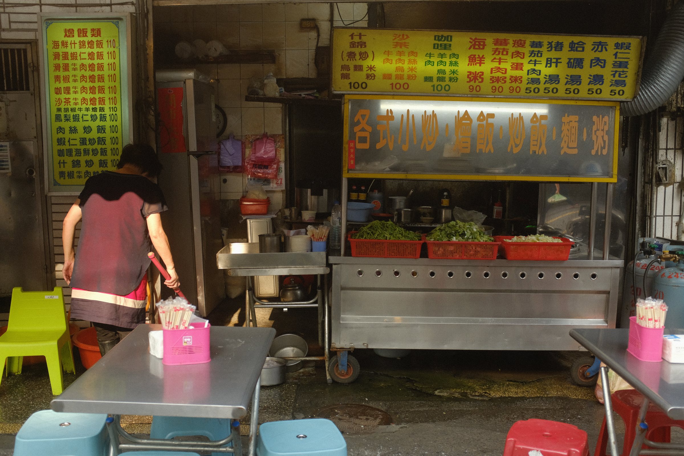 夕方の市場で、屋台の店先に立つ女性