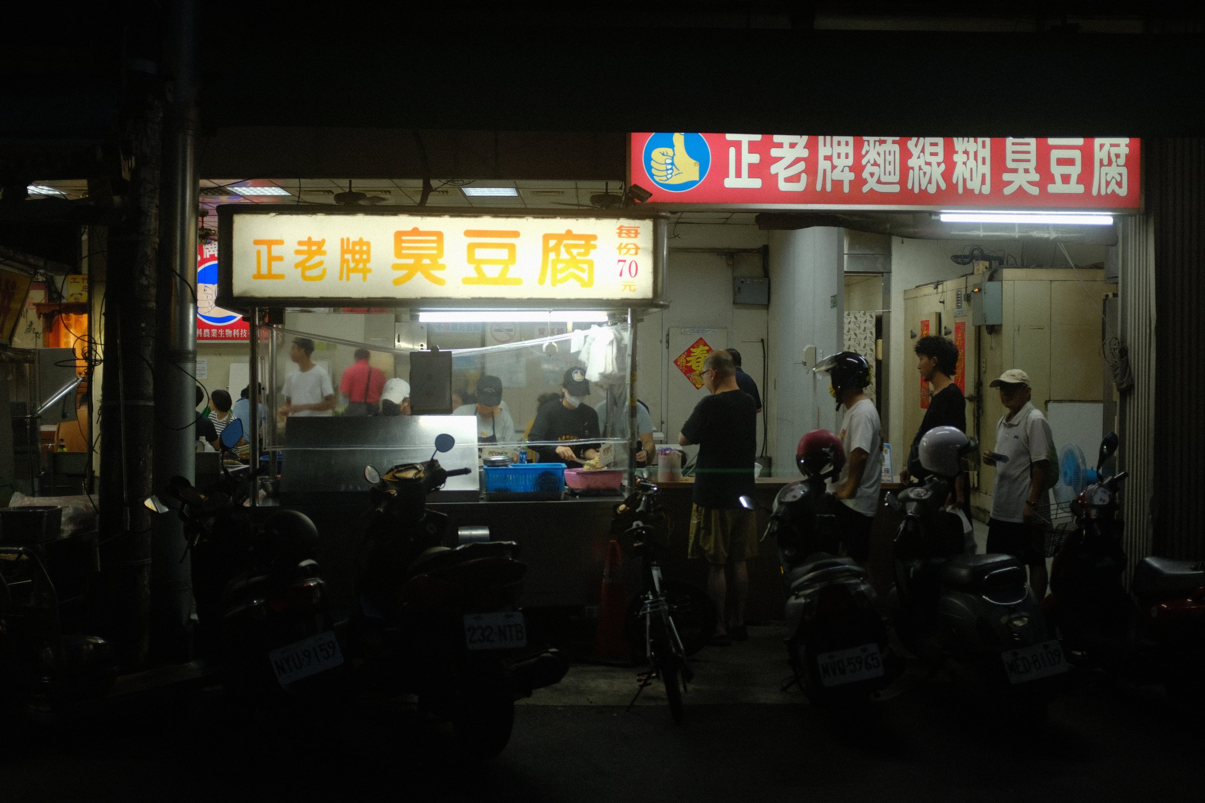 夜の通りに明かりをともす臭豆腐の屋台