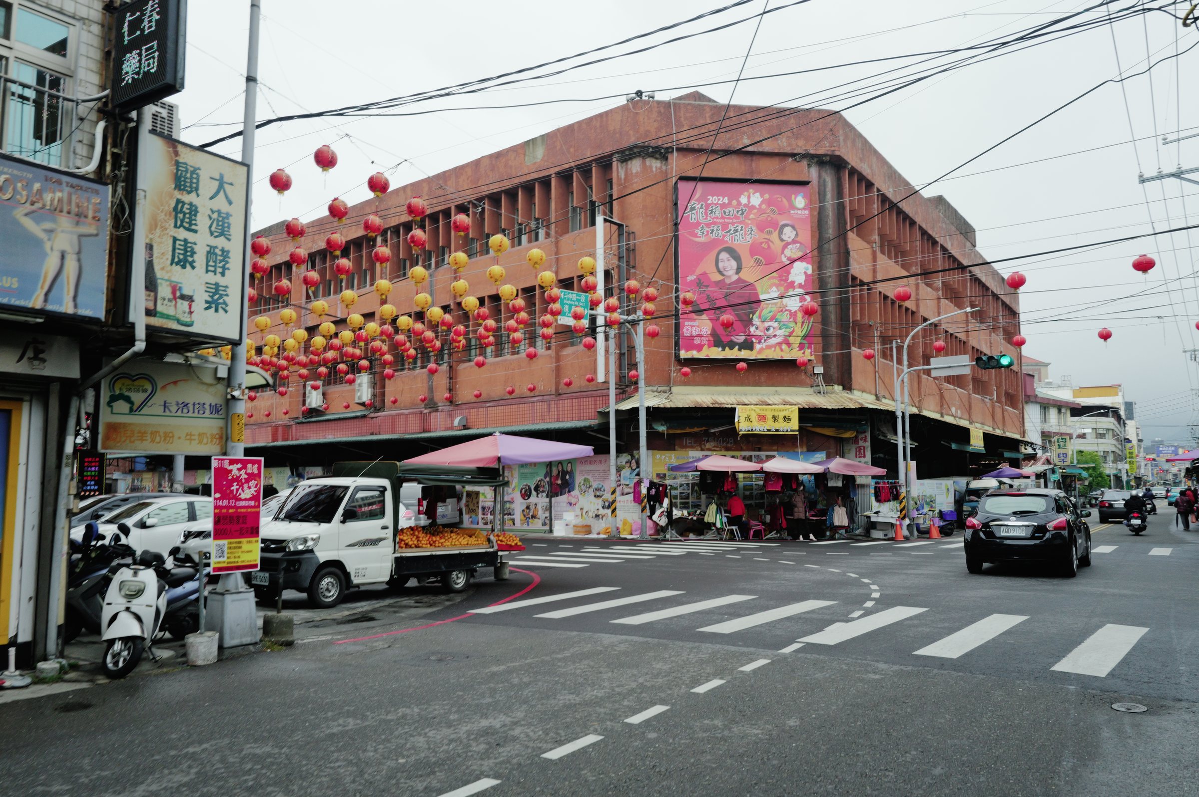 赤い提灯が吊るされた交差点と、古い建物